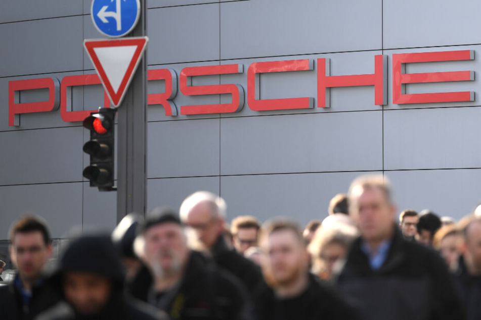 Mitarbeiter von Porsche stehen vor dem Stammsitz des Autobauers in Stuttgart.