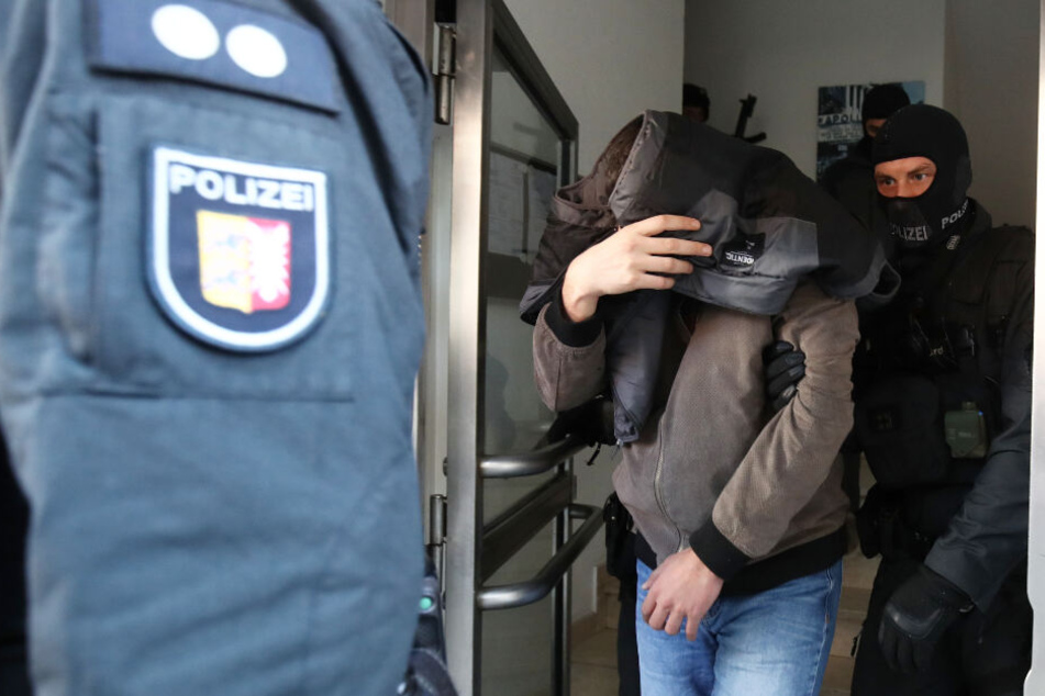 Polizisten führen einen Mann ab.