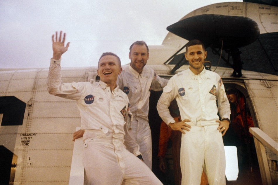 From l. to r.: Commander Frank Borman, Command Module Pilot James Lovell, and Lunar Module Pilot William Anders look up at cheering crewmen on the upper deck of the USS Yorktown, recovery ship for the Apollo 8 mission, on December 27, 1968.