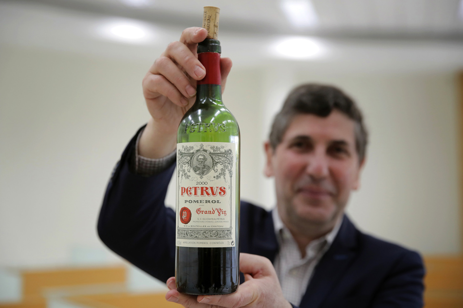Philippe Darriet, Präsident des Instituts für Wein- und Rebenforschung und Chef-Önologe mit der Flasche Petrus-Rotwein, die ein Jahr lang an Bord der ISS um die Erde kreiste.