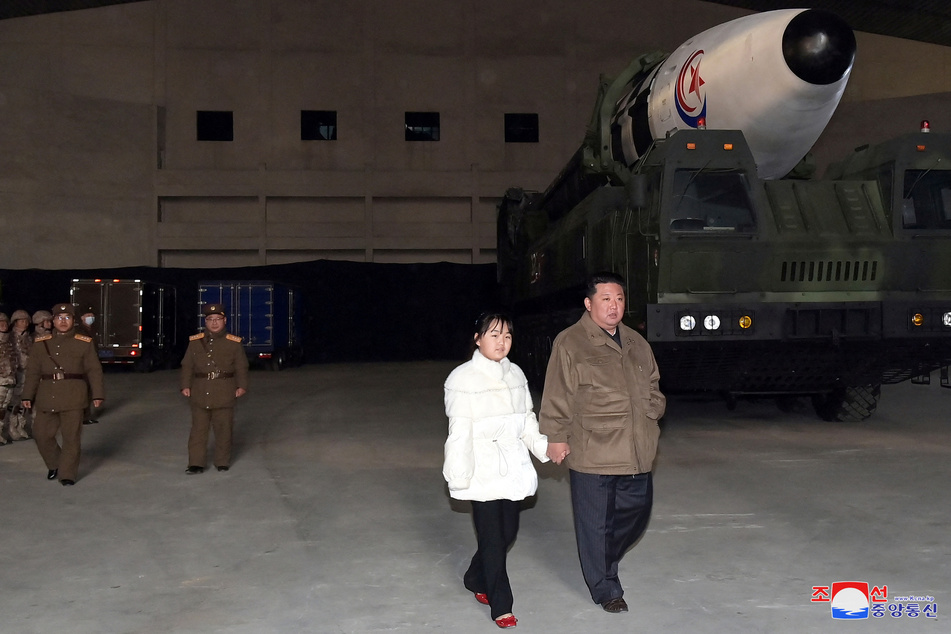North Korean leader Kim Jong Un and his daughter seen walking hand-in-hand next to a ballistic missile.