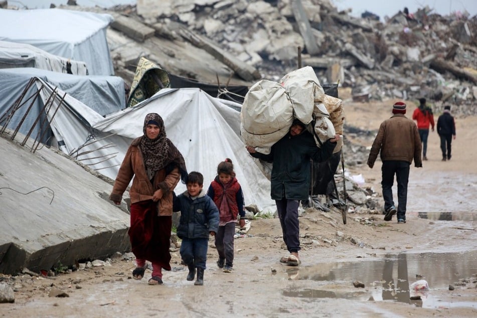 A Palestinian man carries his belongings as he flees with others in Beit Lahia in the northern Gaza Strip on March 21, 2025.