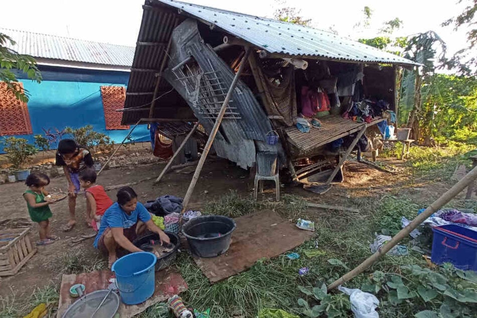 Die Bewohner eines Hauses halten sich im Freien auf, nachdem ihr Zuhause von dem Taifun «Phanfone» zerstört wurde.
