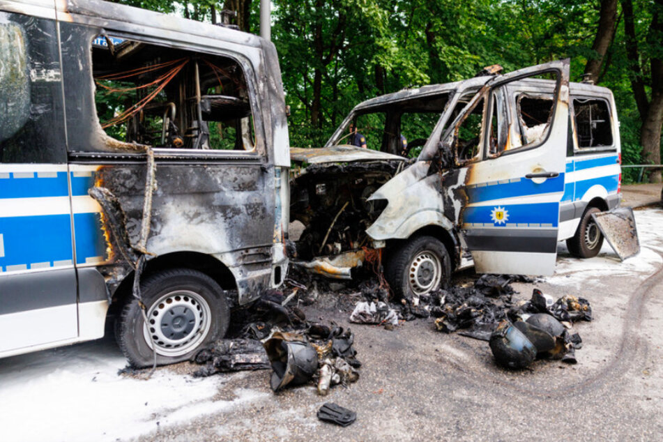 Die ausgebrannten Mannschaftsbusse stehen vor einem Hotel, in dem Polizisten für den G7-Gipfel untergebracht sind.