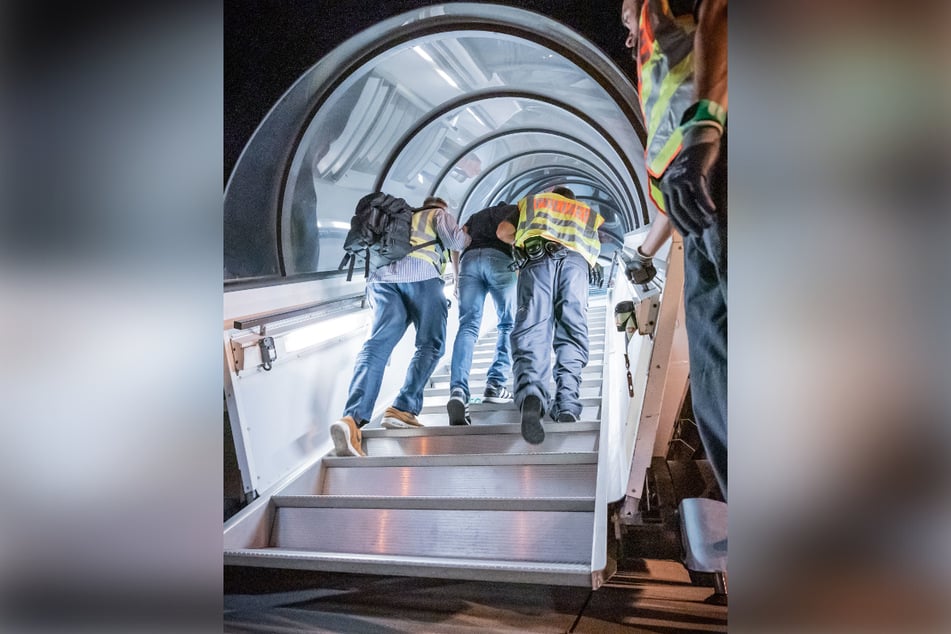 Polizeibeamte begleiten am Flughafen Leipzig einen ausreisepflichtigen Afghanen in ein Charterflugzeug.