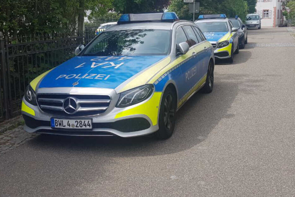 Mehrere Polizeifahrzeuge stehen in einer Straße.