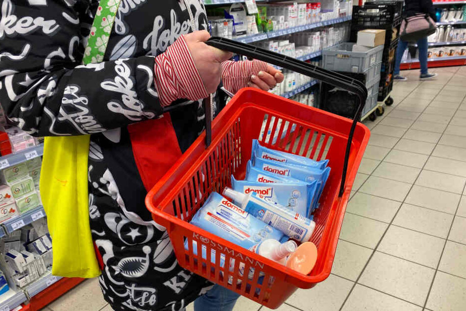 Eine Kundin hat Desinfektionsmittel und Hygiene-Reinigungstücher in der Drogerie gekauft.