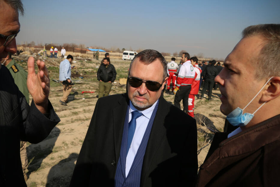 Sergej Burdiljak (Mitte), ukrainischer Botschafter im Iran, steht an der Absturzstelle der ukrainischen Passagiermaschine.