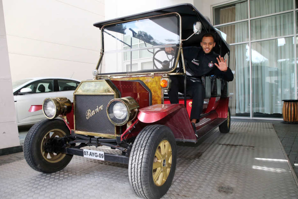 Rückkehrer Louis Samson grüßt aus einem Oldtimer.