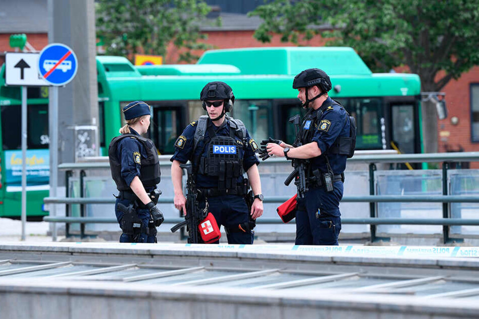 Polizisten stehen am Tatort, wo die Polizei einen Mann angeschossen und verletzt hat, er bedrohte andere Menschen.