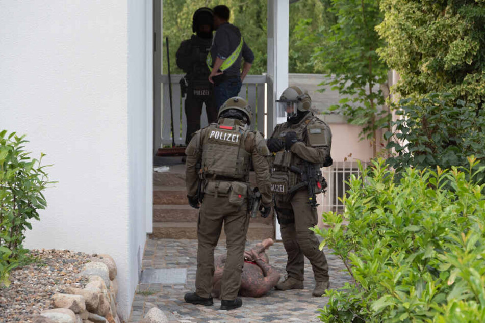 Spezialkräfte der Polizei mit einem der Tatverdächtigen.