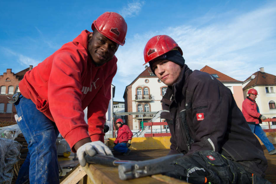 Vincent Ahondoh (l.) und Sven Hofmann, Auszubildende in der Bauwirtschaft auf einer Baustelle in Esslingen.