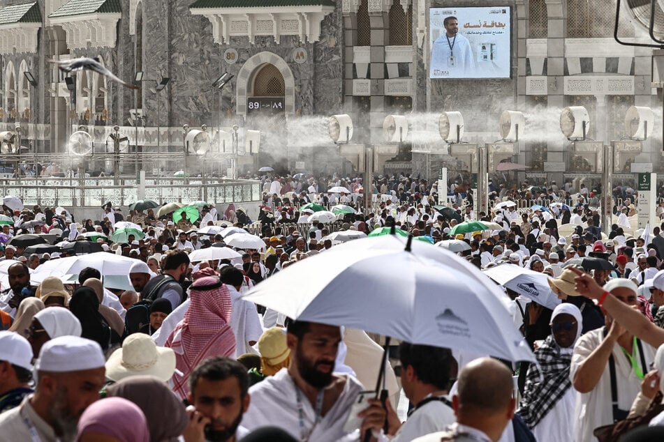 Muslim worshippers walk along the Grand Mosque complex under the water-mist fans installed in the holy city of Mecca on May 24, 2026.