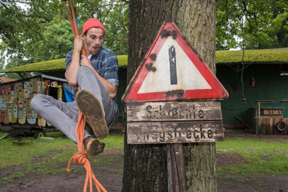 Der Netzwerker Fynn Kliemann schwingt an einem Seil über seinen Kreativhof "Kliemannsland" in Dorf (Niedersachsen).
