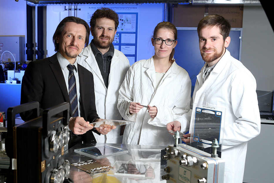 TU-Professor Thomas von Unwerth erklärt Forschern das Modell einer Brennstoffzelle.