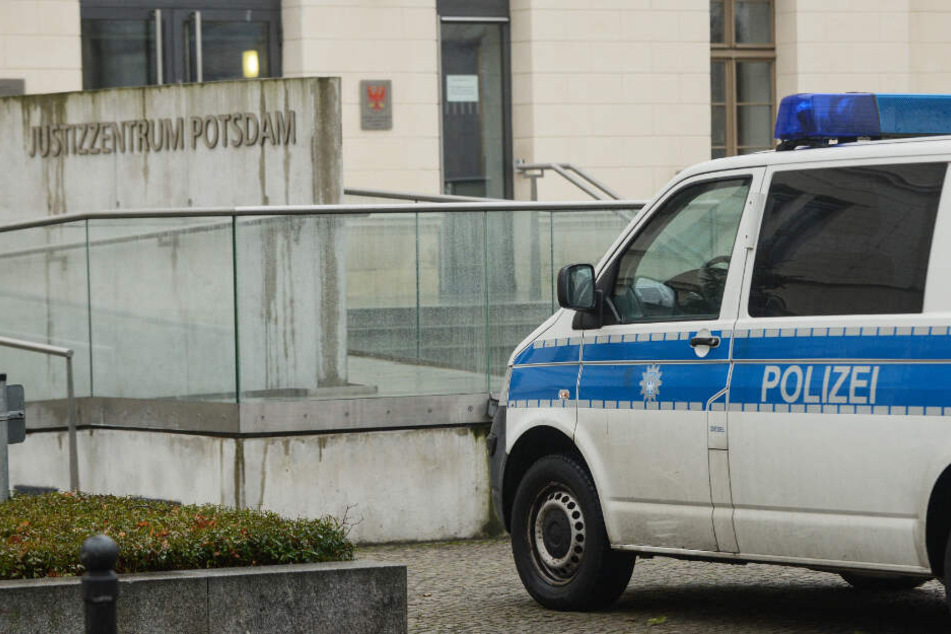 Nach einer Bombendrohung steht ein Polizeifahrzeug am Justizzentrum Potsdam.