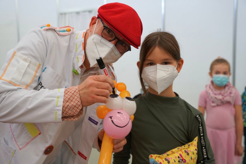Ein Lächeln für die tapferen Besucher des Piks-Zentrums der Messe Dresden. Der Impf-Clown hat zahlreiche Ballon-Tiere parat und belustigt Familien.