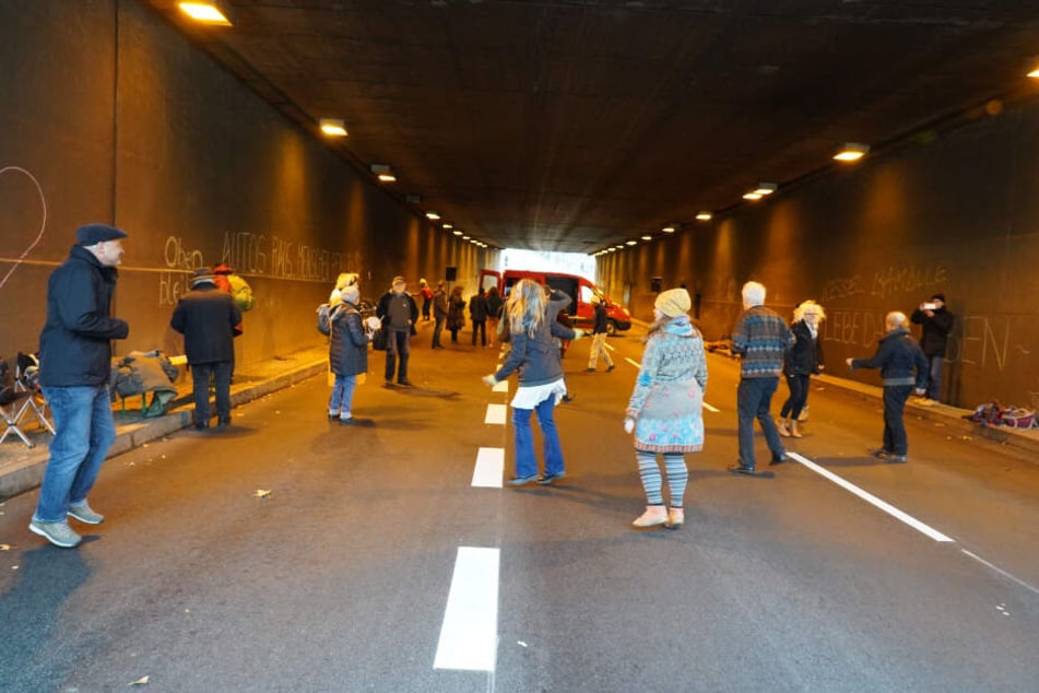 Die Demonstranten tanzen zu DJ-Musik im Tunnel auf der B14.