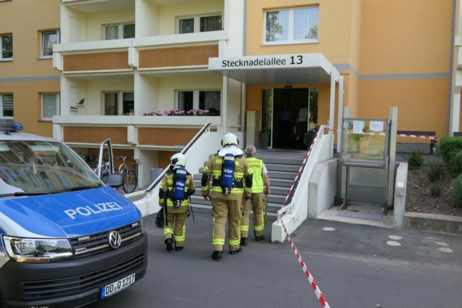 Kameraden der Feuerwehr betreten mit Atemschutz die Wohnung des Mannes.