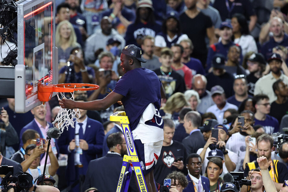 UConn's Adama Sanogo cutting the net after racking up 17 points and 10 rebounds against the Aztecs.