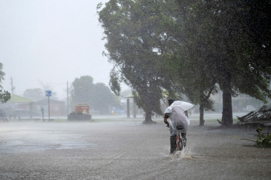 A resident tried to bicycle through a flooded street in the aftermath of Hurricane Fiona in Salinas, Puerto Rico.