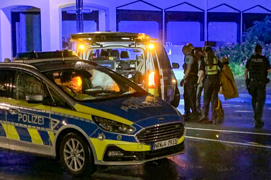 Am späten Samstagabend stellt sich ein Mann (hinten verdeckt zwischen Polizisten) bei der Polizei auf offener Straße und gibt an der Täter zu sein.