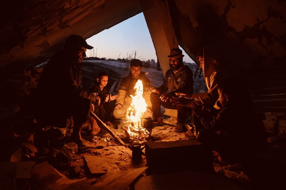 Anwohner im Gaza-Streifen wärmen sich an einem Feuer.
