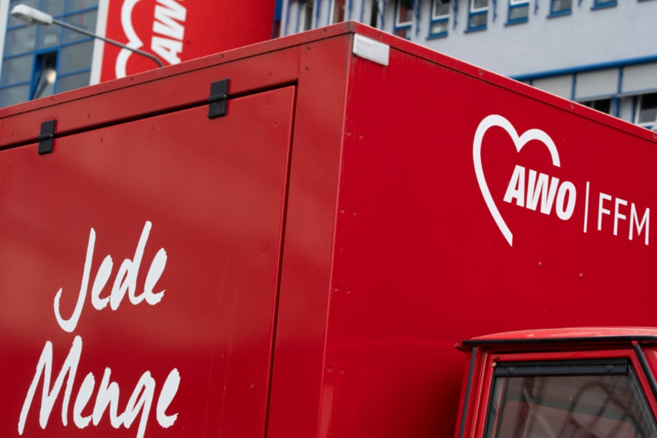 "Jede Menge" steht auf einem AWO-Fahrzeug, welches vor der AWO-Zentrale in Frankfurt geparkt ist.