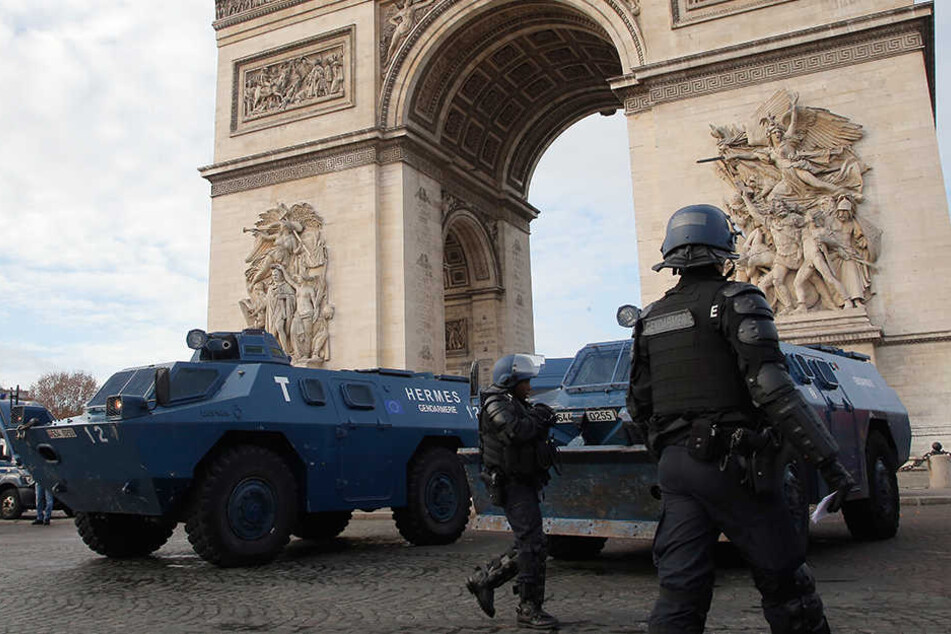 Polizisten und Räumpanzer stehen vor dem Triumphbogen in Paris.