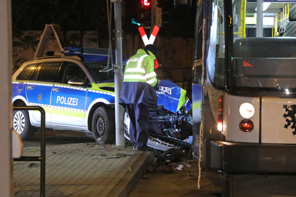 Ein Mitarbeiter der Polizei steht am Polizeiwagen, der in die Bahn krachte.