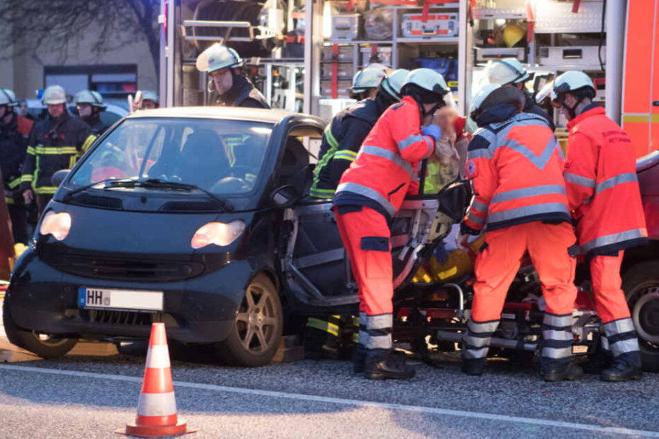 Rettungskräfte befreien die eingeklemmte Fahrerin aus dem Auto.