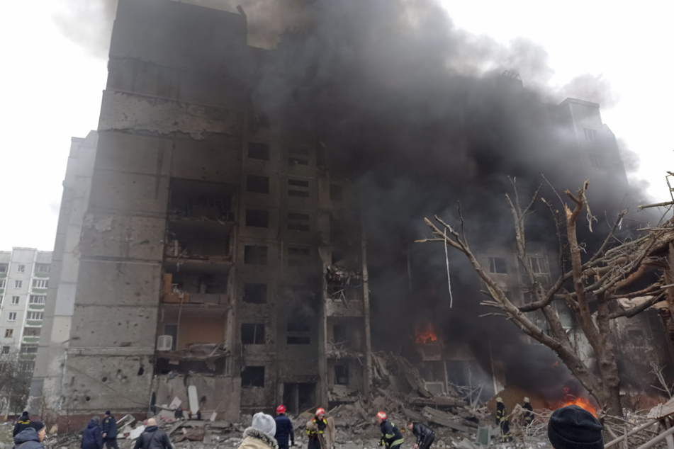 Feuerwehrleute löschen ein Feuer im beschädigten Stadtzentrum von Tschernihiw nach einem russischen Luftangriff.