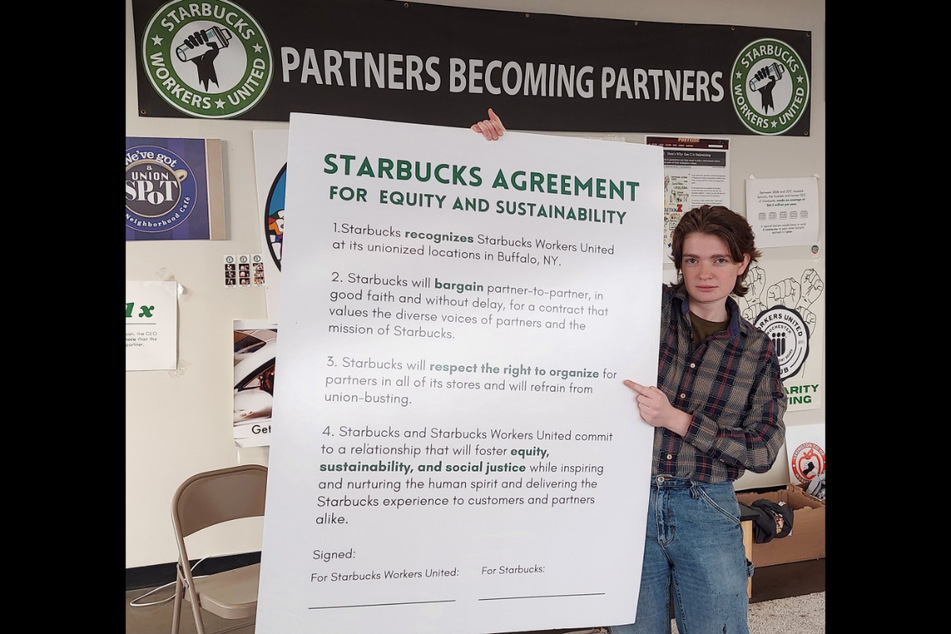 Jaz Brisack, a Buffalo union organizer the NLRB has ordered Starbucks to reinstate, holds up an equity and sustainability agreement devised by Starbucks Workers United.