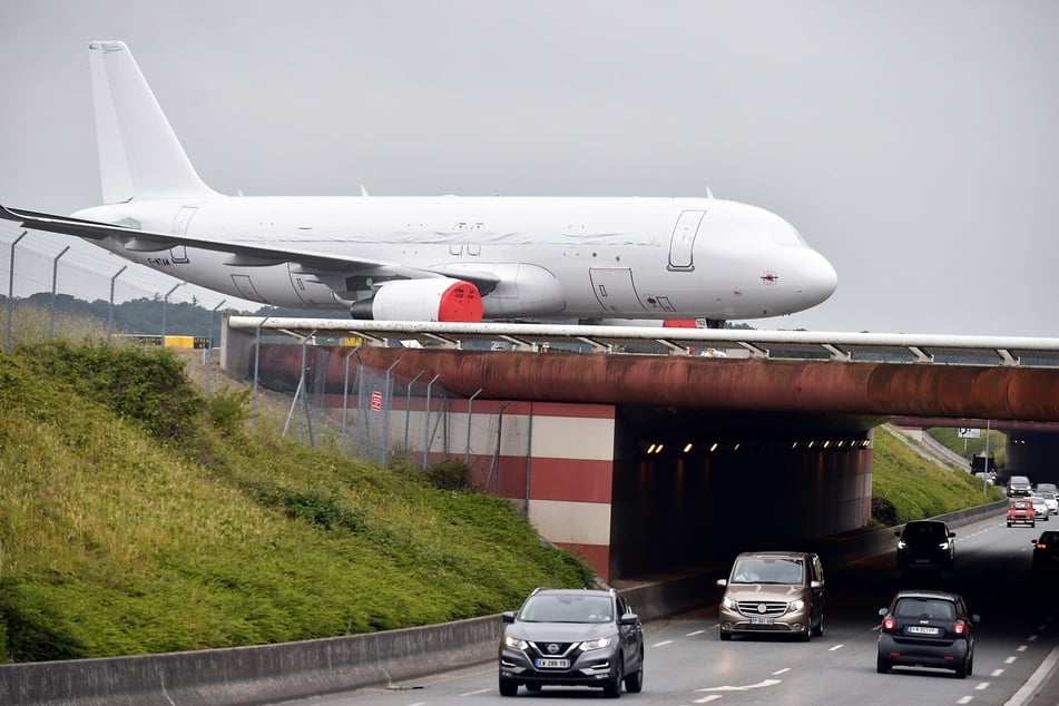 Ein Airbus A320-Flugzeug überquert auf einer Rollbrücke am Hauptsitz des Airbus-Unternehmens im südfranzösischen Blagnac eine Autobahn.