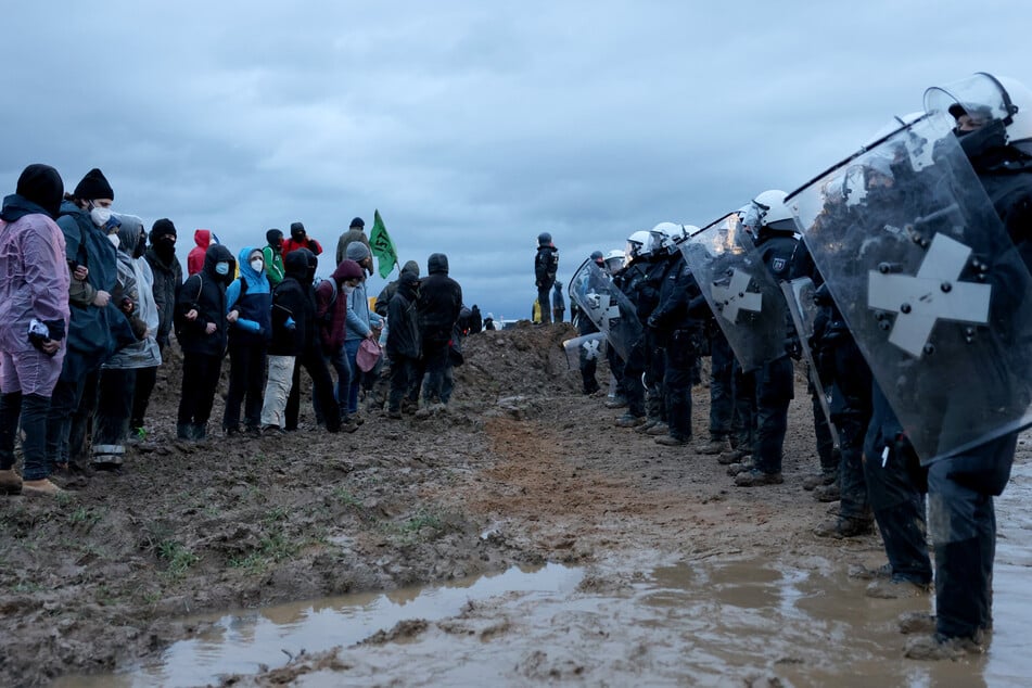 Polizisten und Demonstranten stehen sich im Januar 2023 bei der Demonstration von Klimaaktivisten am Rande des Braunkohletagebaus bei Lützerath gegenüber.