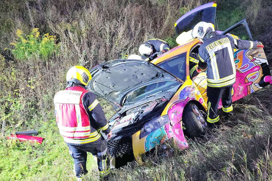 Einsatzkräfte der Feuerwehr begutachten den Unfallwagen.