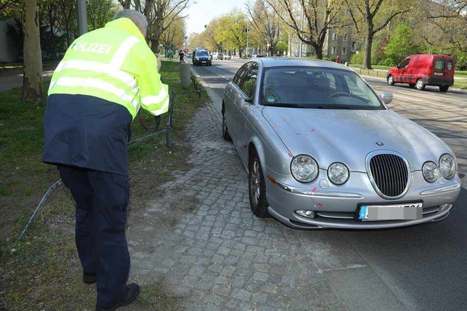 Ein Polizist macht Aufnahmen von dem Unfall-Auto.