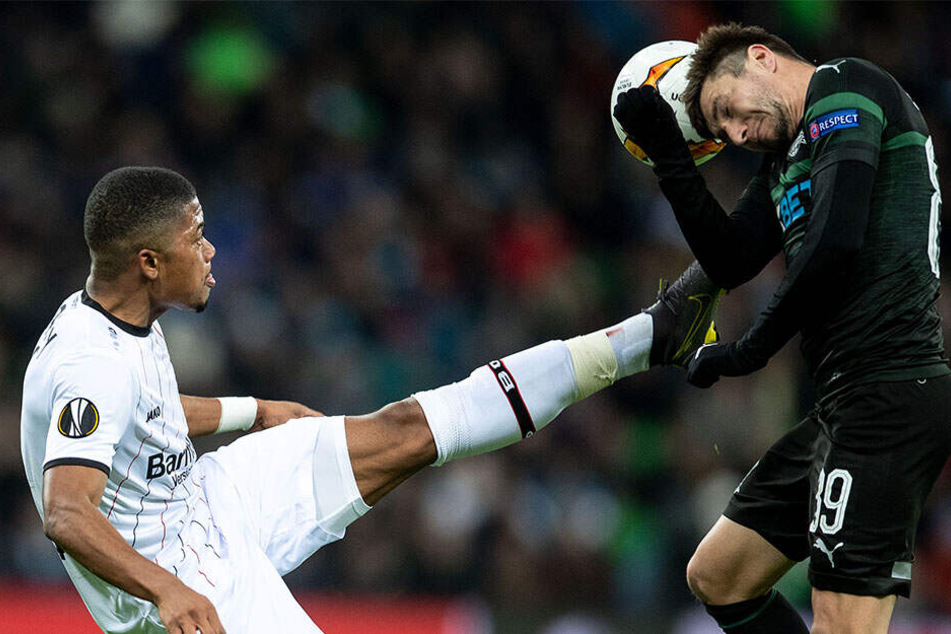 Hoch das Bein! Leverkusens Leon Bailey (l.) geht nur auf den Ball. Für Krasnodars Dmitri Stotski heißt es: Augen zu und durch.