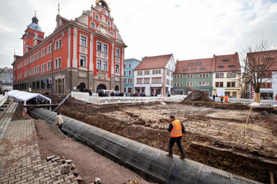 Ein Bauarbeiter läuft auf dem eingehausten Leinakanal, während das Landesamt für Denkmalpflege und Archäologie bei einer Führung die freigelegten Überreste der Jakobskapelle am Gothaer Hauptmarkt vorstellt.