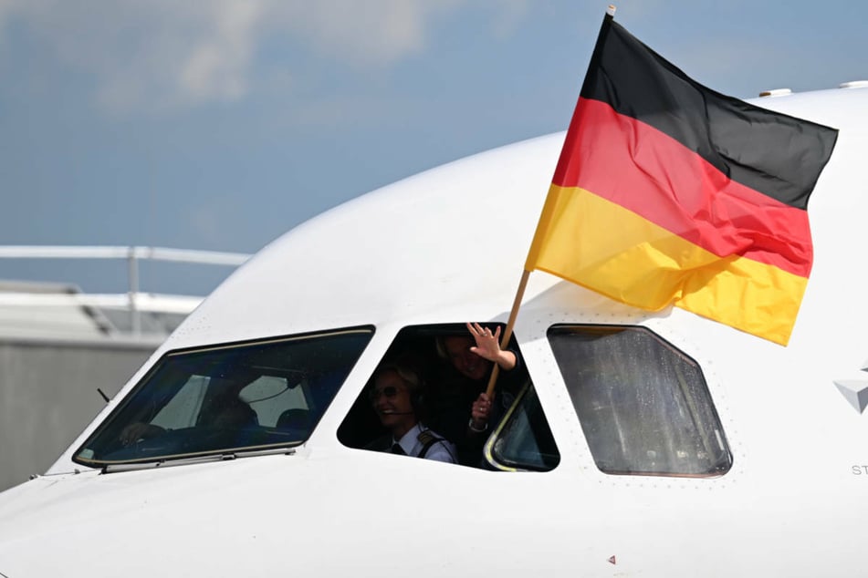 Die Bundestrainerin schwenkt bei der Landung eine deutsche Flagge aus der Pilotinnen-Kanzel.
