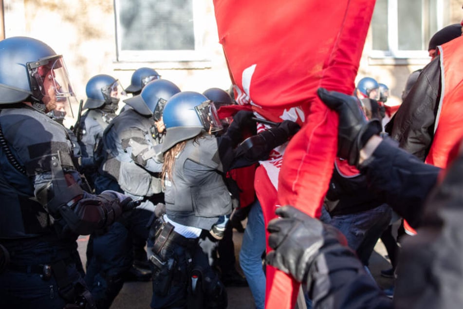 Polizisten schieben Demonstranten zur Seite.