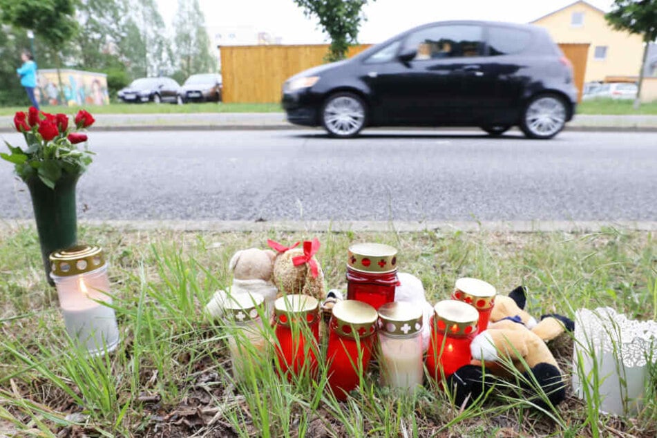 Blumen, Kerzen und Plüschtiere stehen an der Stelle am Straßenrand in Rostock, wo der tote Säugling gefunden wurde.