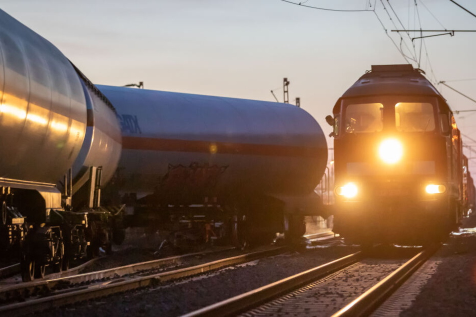 Ein Zug mit einem Bergekran fährt an einem Entgleisten Waggon vorbei.