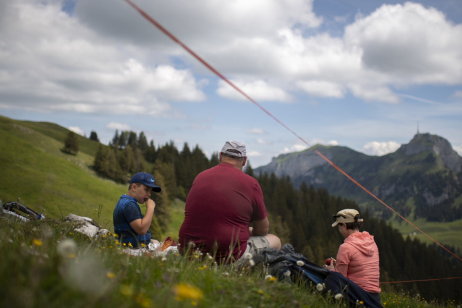 Schweiz, Brülisau: Eine Familie picknickt auf der Alp Sigel mit Blick auf den Hohen Kasten.
