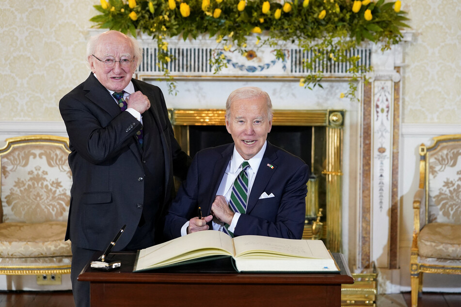 US President Joe Biden signs the guest book as he meets with Irish President Michael Higgins in Dublin, Ireland.
