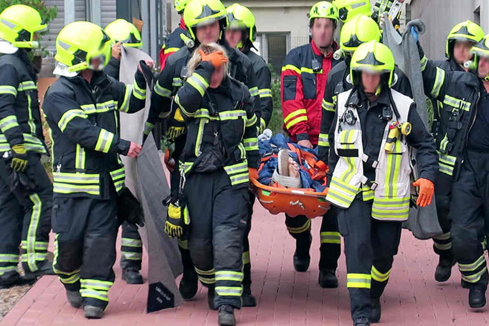 Vorsichtig tragen Sanitäter und Feuerwehrleute den verletzten Chemnitzer zum Krankenwagen.