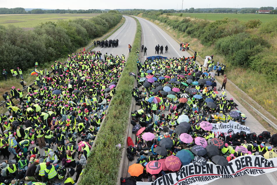 Demonstranten protestieren auf der Autobahn.