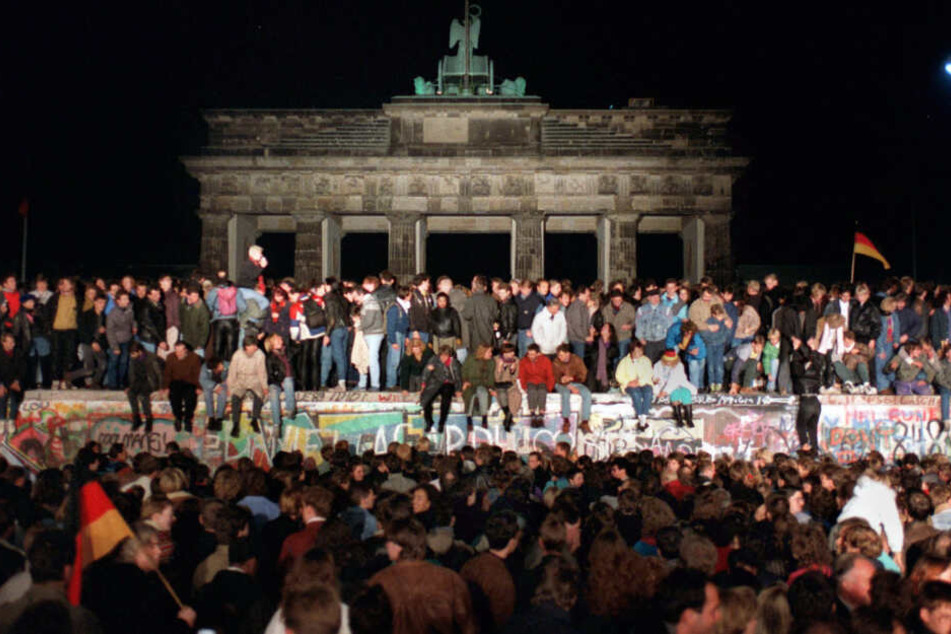 10. November 1989: Jubelnde Menschen auf der Berliner Mauer am Brandenburger Tor.