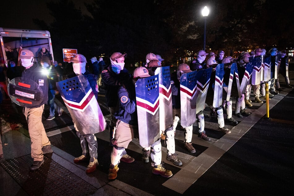 Members of the rightwing group Patriot Front wait along the George Washington Parkway near Arlington Cemetery after marching on the National Mall on December 04, 2021 in Arlington, Virginia.