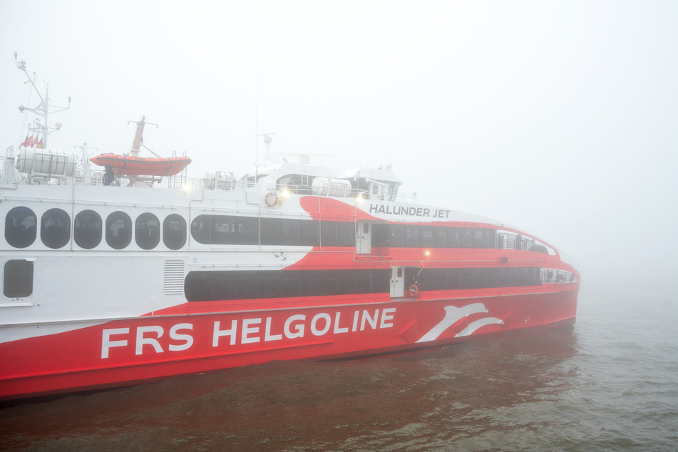 Der Helgoland-Katamaran "Halunder Jet" legt am Morgen im dichten Nebel im Hafen auf der Elbe in Richtung der Nordseeinsel Helgoland ab.